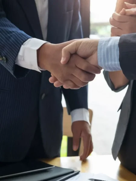 Business professionals shaking hands during a legal or corporate meeting